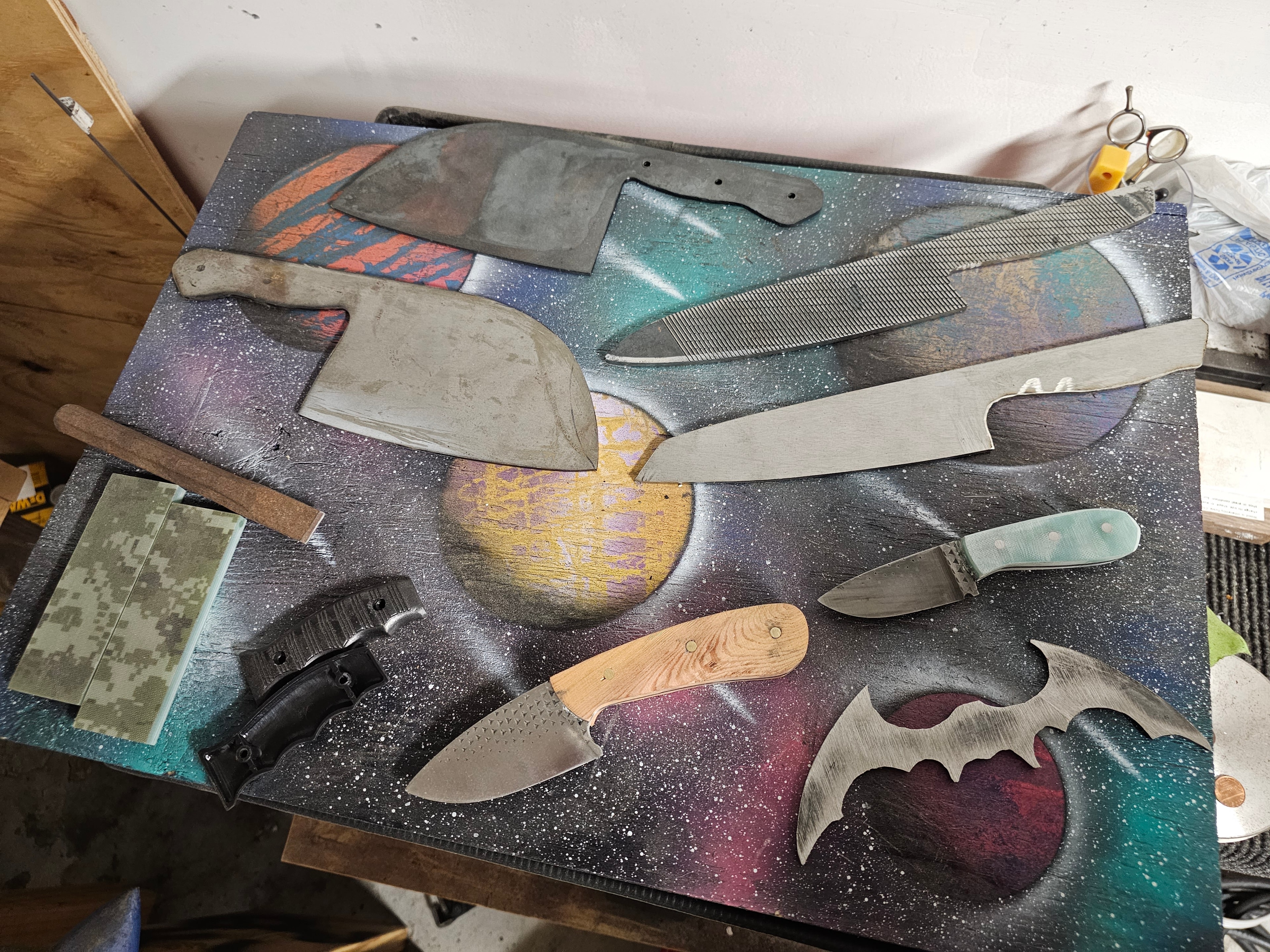 Custom knife collection displayed on galaxy artwork board
