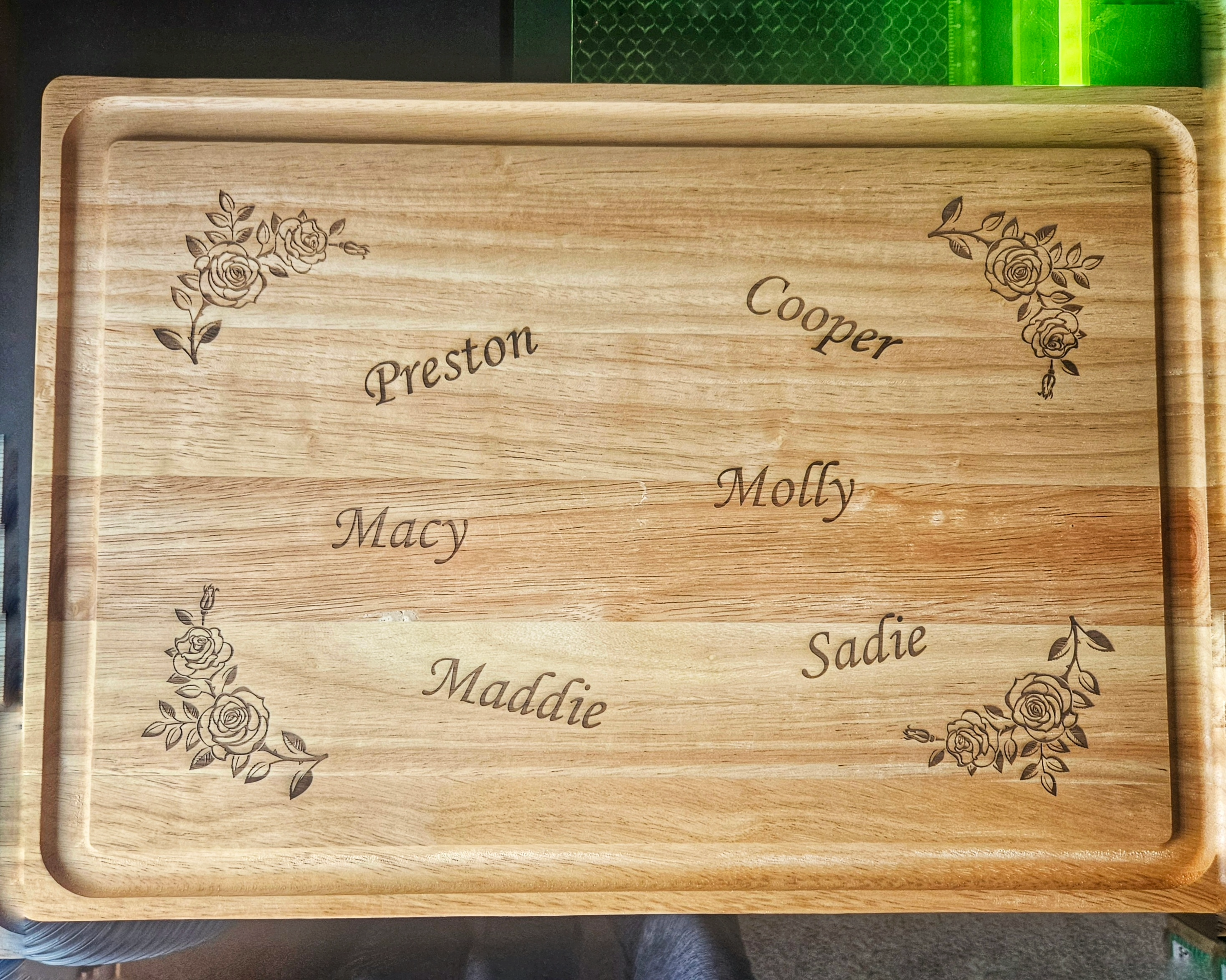 Personalized laser engraved cutting board with family names and rose designs